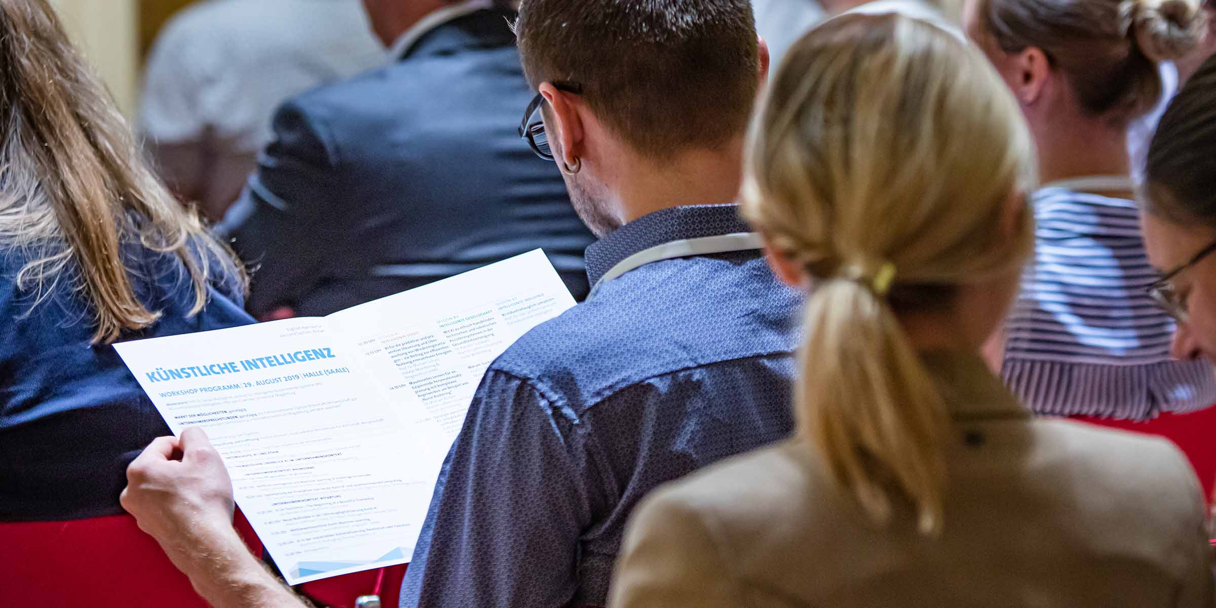 Ein Mann liest die Broschüre über künstliche Intelligenz auf der Digitalen Agenda für das Land Sachsen-Anhalt