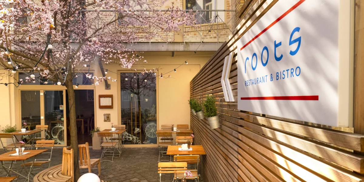 roots Restaurant & Bistro – Innenhof mit Schild