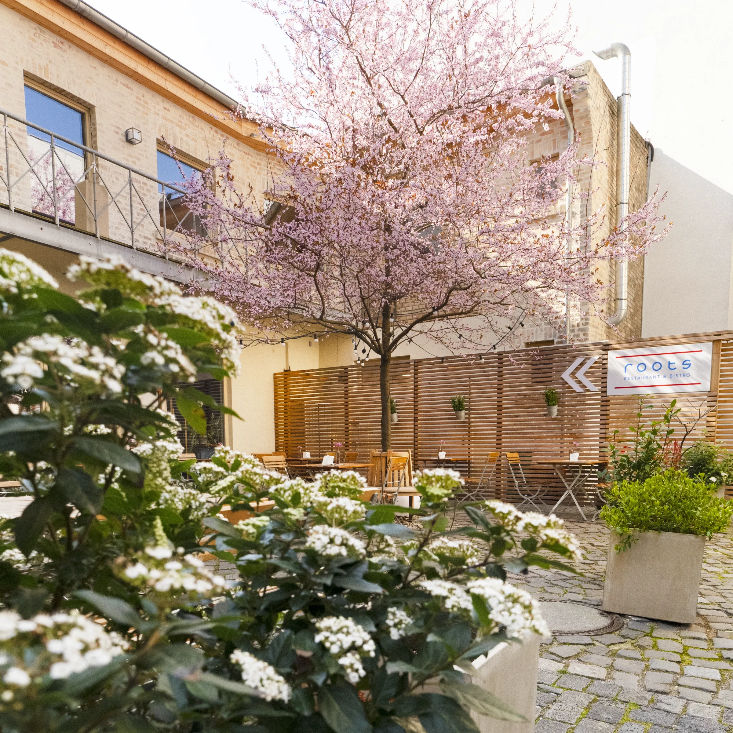 roots Restaurant & Bistro – Innenhof mit Schild