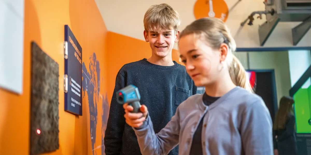 Zwei Jugendliche messen die Oberflächentemperatur von Metall in der Ausstellung Messlabor im Historischen Technikzentrum der Stadtwerke Halle